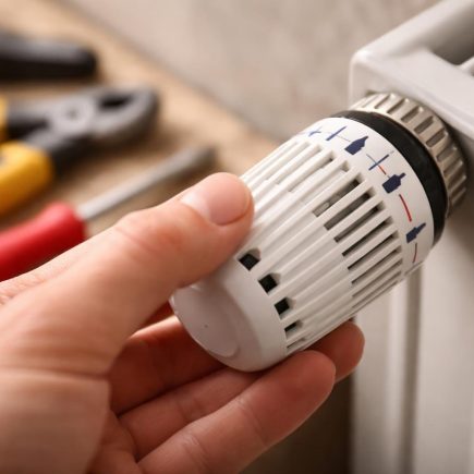main-thermostat-radiateur-arriere-plan-flou