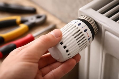 main-thermostat-radiateur-arriere-plan-flou